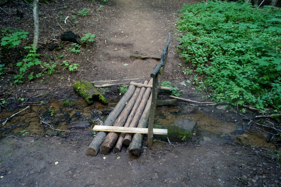 Мостик через родниковый ручей, который затем падает водопадом